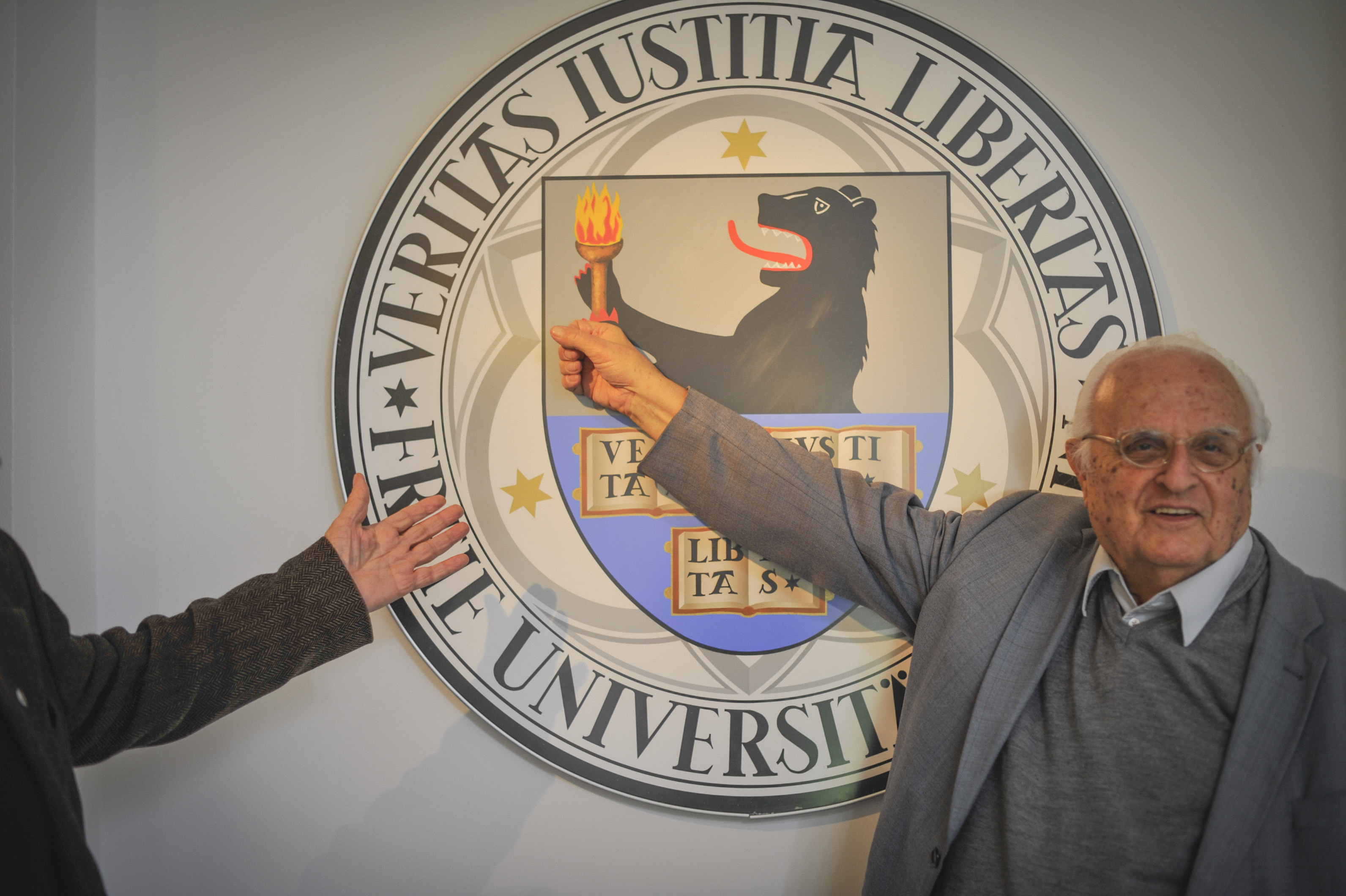 Prof. Dr. Stanislaw Karol Kubicki vor dem Logo der Freien Universität Berlin