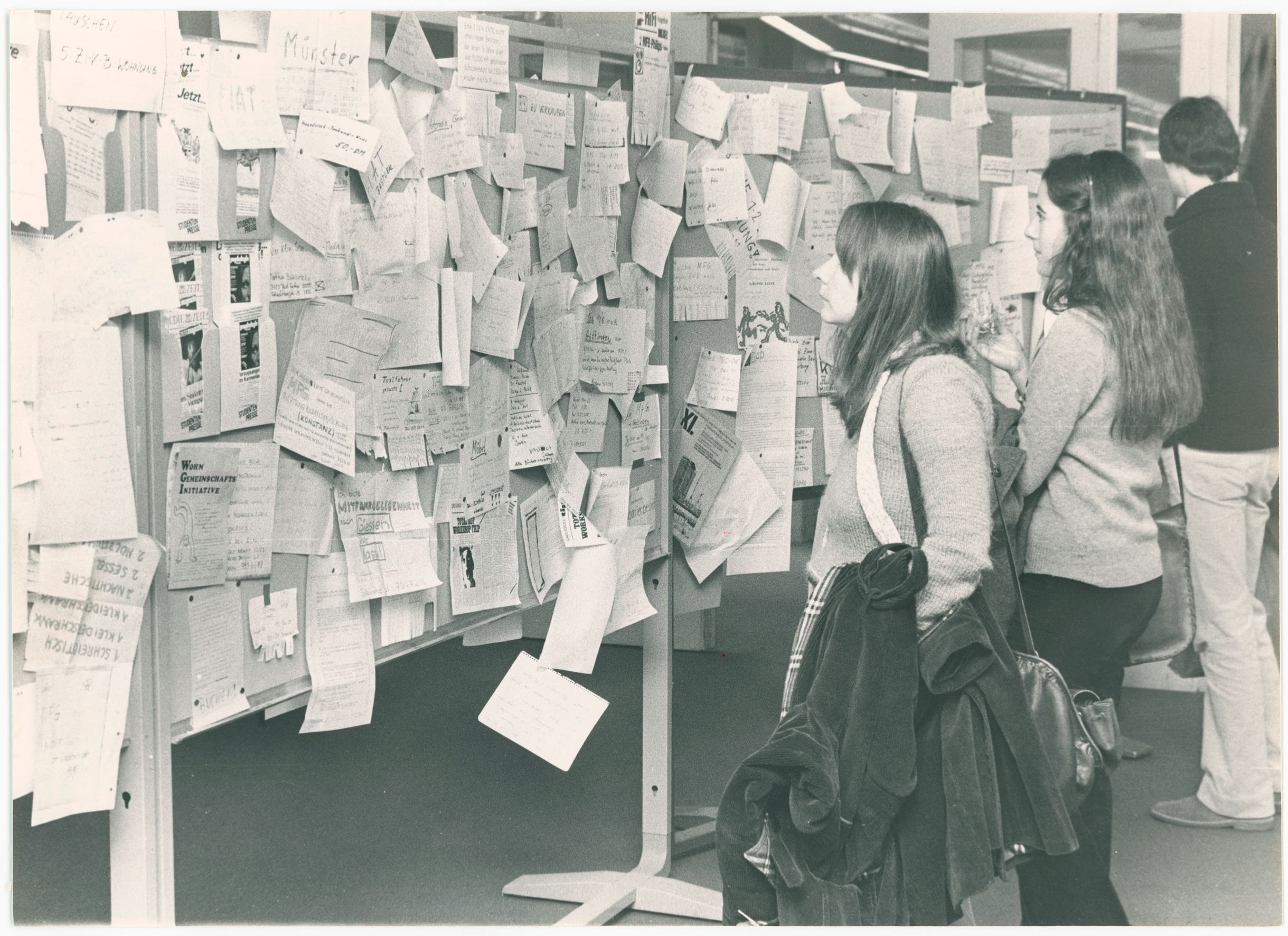 Studierende vor dem schwarzen Brett in der Rostlaube 